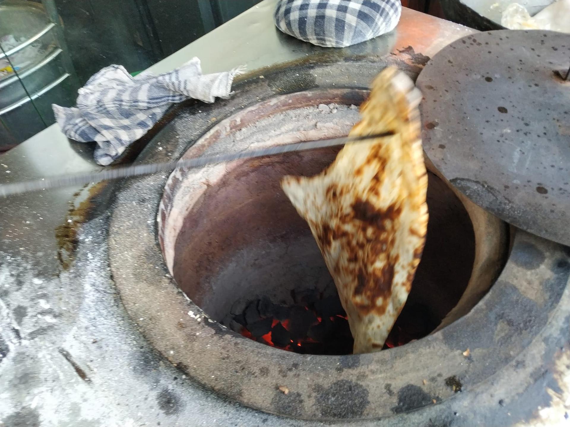 Fresh naan lifted from the tandoor on a skewer